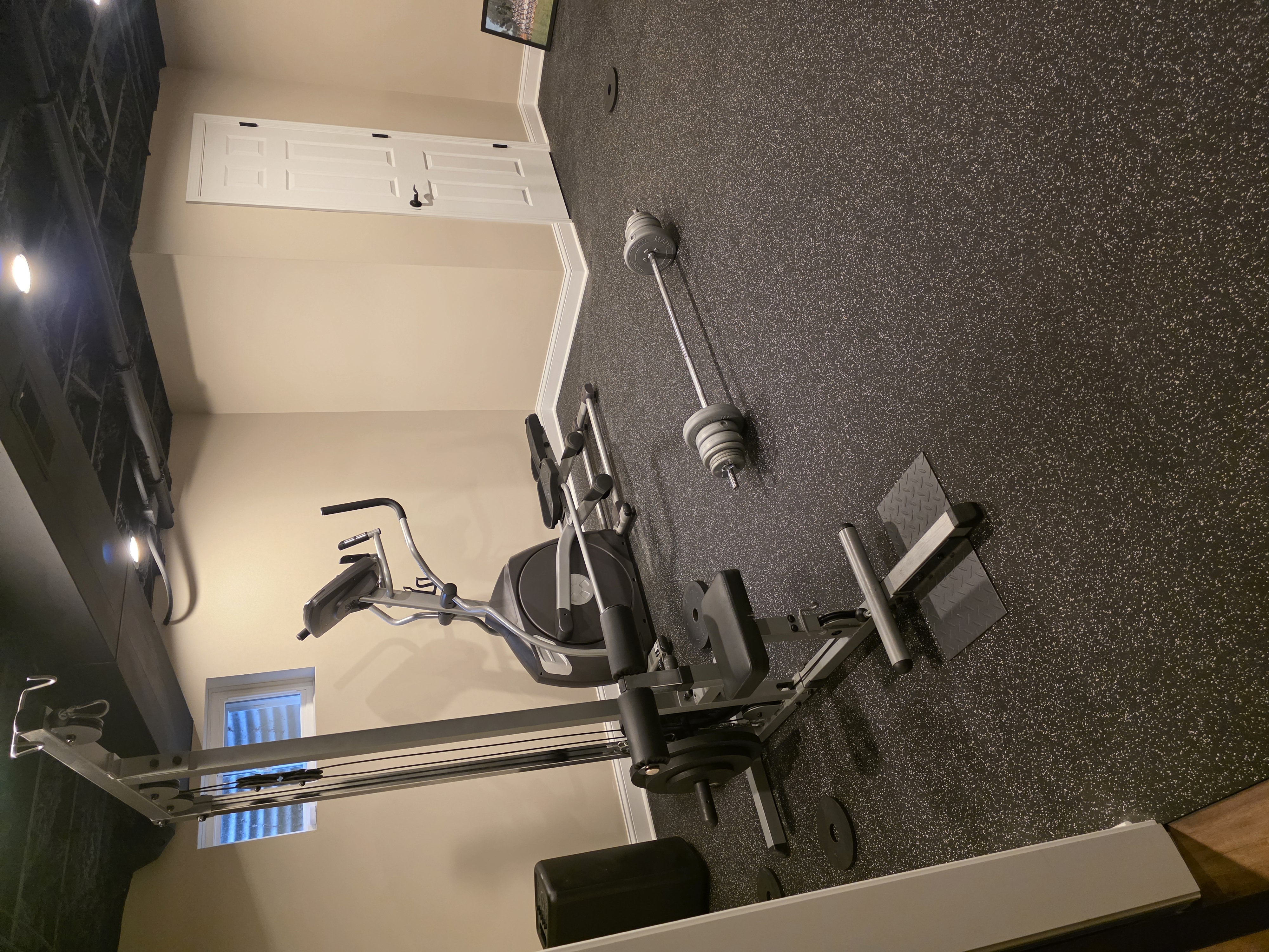 Basement gym room with rubber flooring and barn door