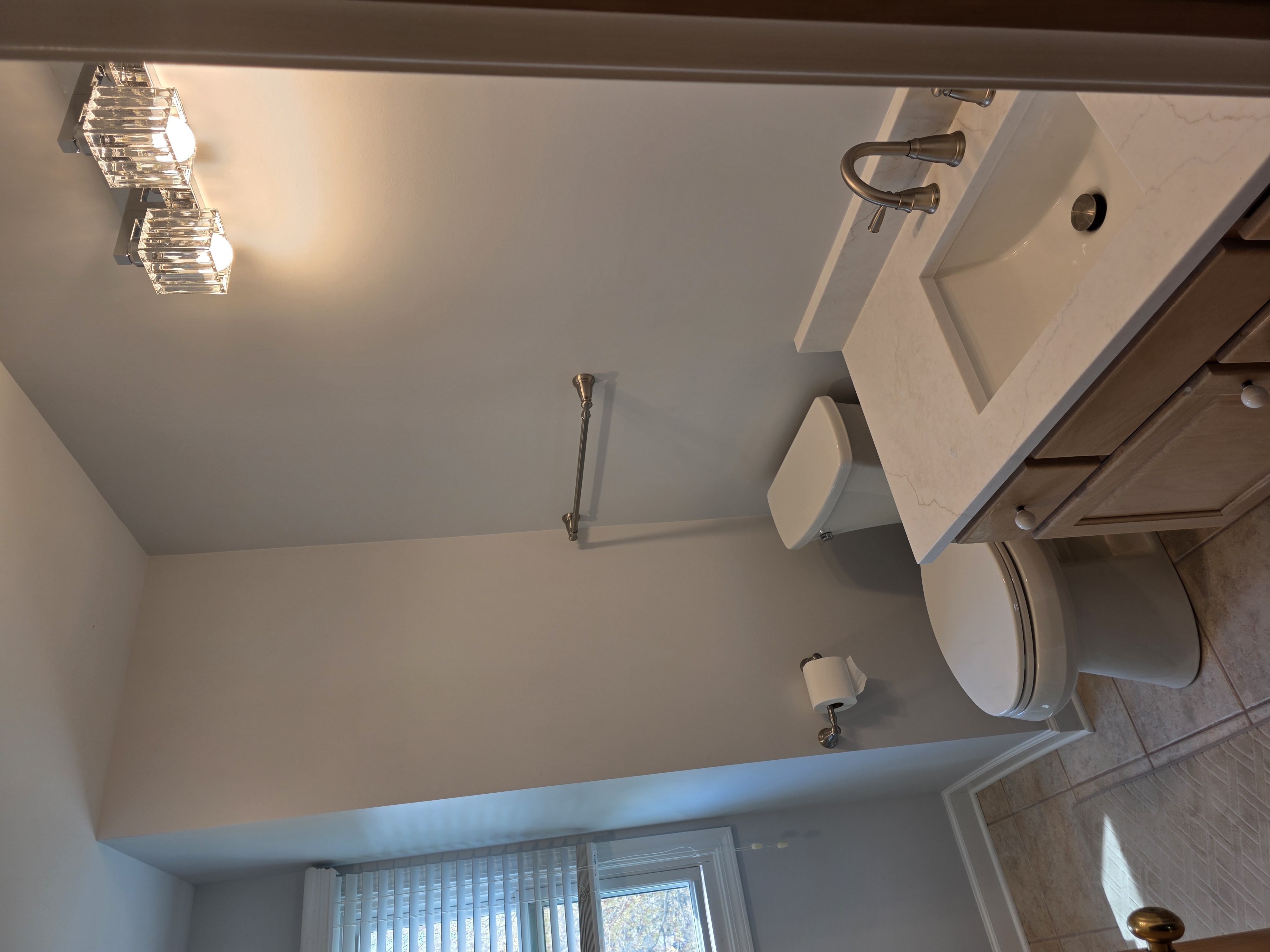 Bathroom with quartz vanity and crystal light fixture