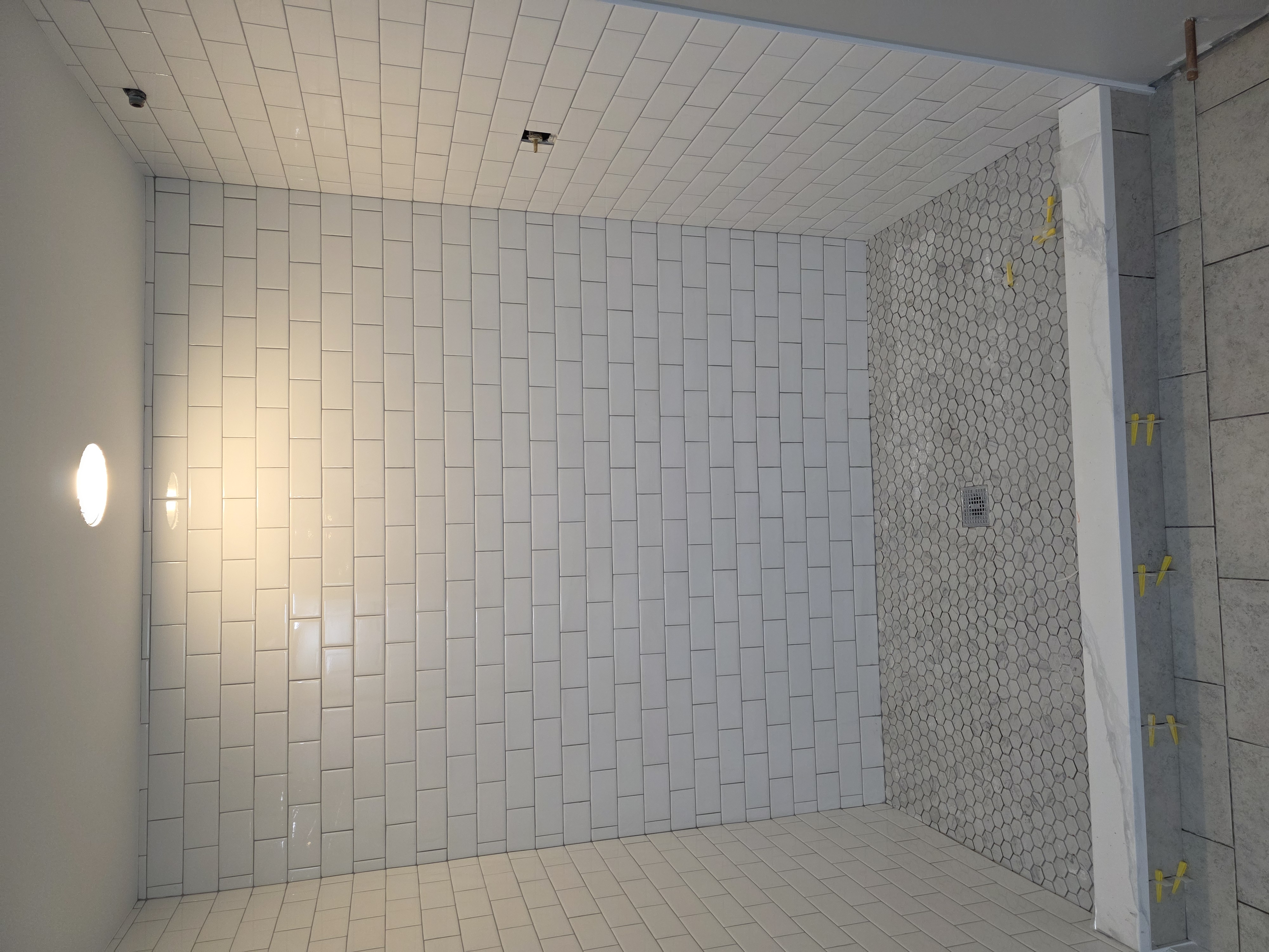 White subway tile shower in progress — tile craftsmanship