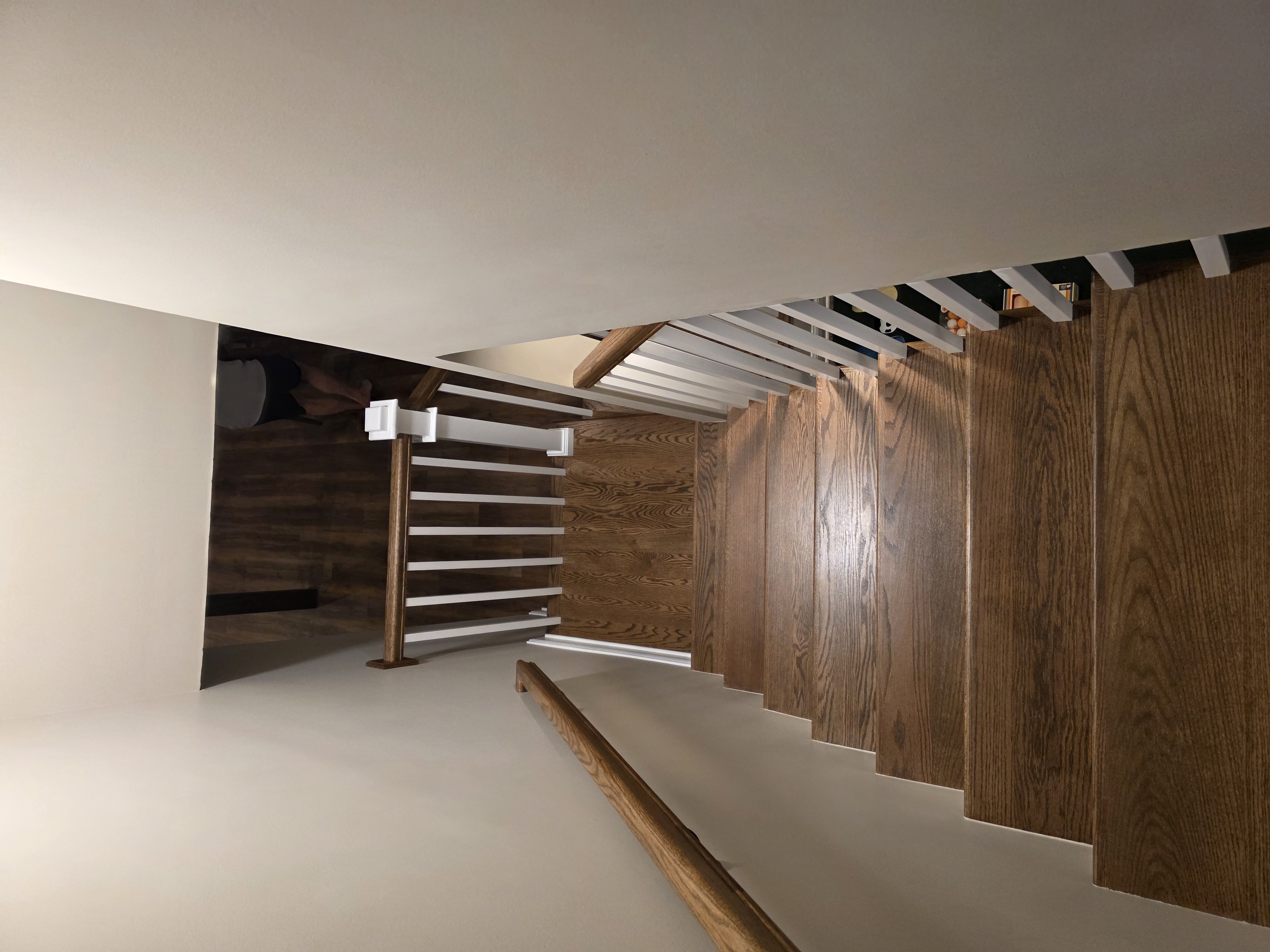 Hardwood staircase with white balusters by M&M Construction